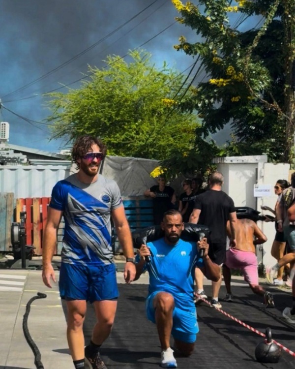 Coach Didier coaching athlete with sandbag lunges